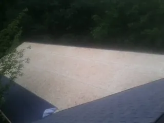 New OSB roof sheathing installed beside an existing shingle roof in Greenville
